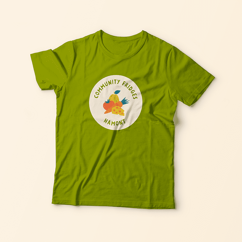 A green t shirt with the Community Fridges Hamont circle logo printed on it.