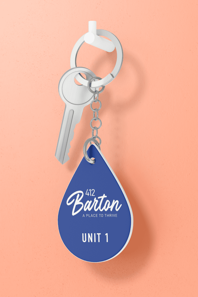 A blue keychain on a peach coloured background